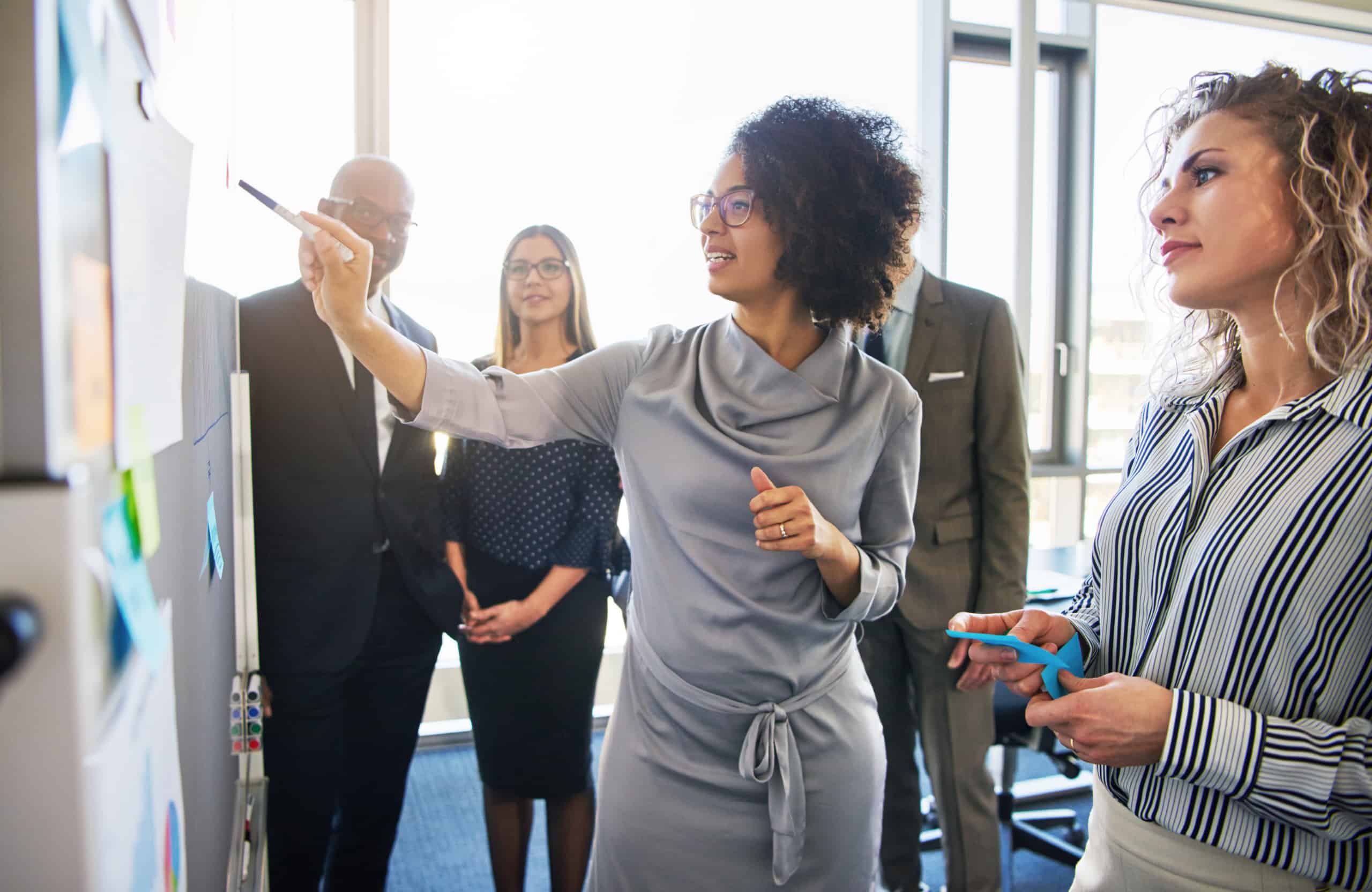 Diverse,Group,Of,Focused,Businesspeople,Brainstorming,Together,On,A,Whiteboard